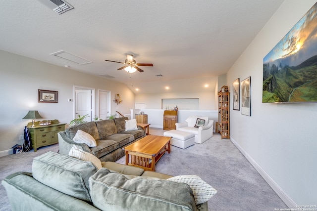 living room with attic access, visible vents, baseboards, and light colored carpet