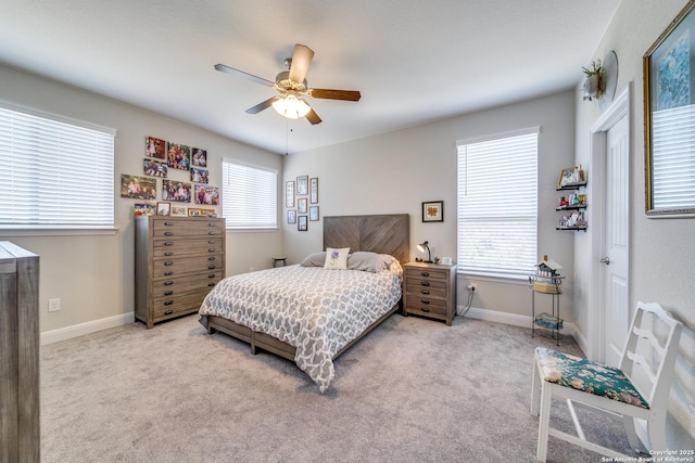 bedroom with light carpet, multiple windows, and baseboards