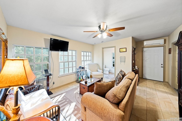 living area featuring an AC wall unit, light tile patterned flooring, and a ceiling fan