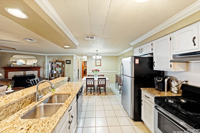 kitchen with stainless steel appliances, a sink, visible vents, white cabinetry, and hanging light fixtures