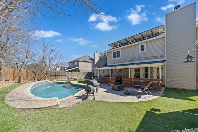 view of pool with a patio, an outdoor fire pit, fence, a yard, and a fenced in pool