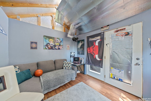 living area featuring vaulted ceiling with beams and wood finished floors