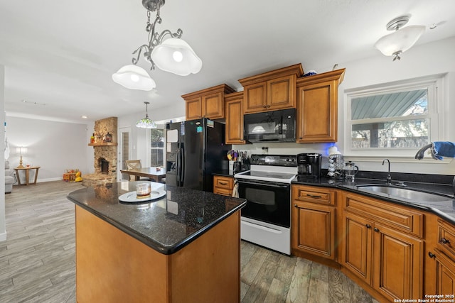 kitchen with a kitchen island, a sink, hanging light fixtures, and black appliances