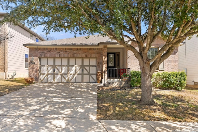 ranch-style house featuring concrete driveway, an attached garage, brick siding, and roof with shingles