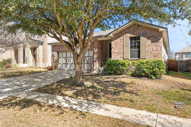 ranch-style house featuring brick siding, concrete driveway, a garage, and fence