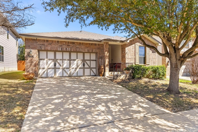 ranch-style house with concrete driveway, an attached garage, brick siding, and a shingled roof