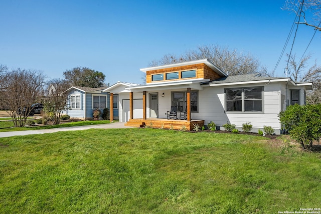 view of front of house with a porch, a garage, driveway, and a front lawn