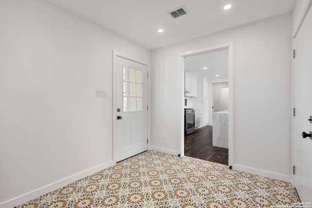 foyer entrance featuring tile patterned floors, baseboards, visible vents, and recessed lighting