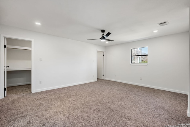 unfurnished bedroom with carpet, visible vents, a spacious closet, and baseboards