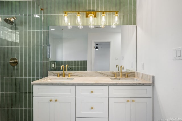 bathroom featuring double vanity, a sink, and tiled shower