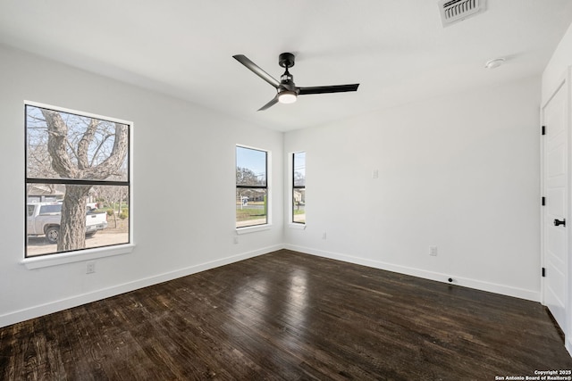 spare room featuring a ceiling fan, dark wood finished floors, visible vents, and baseboards