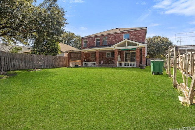 back of house with fence private yard, a porch, a lawn, and brick siding