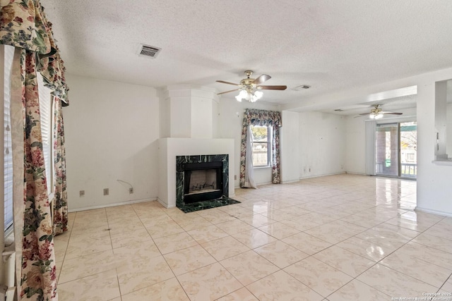 unfurnished living room with light tile patterned flooring, plenty of natural light, visible vents, and a high end fireplace