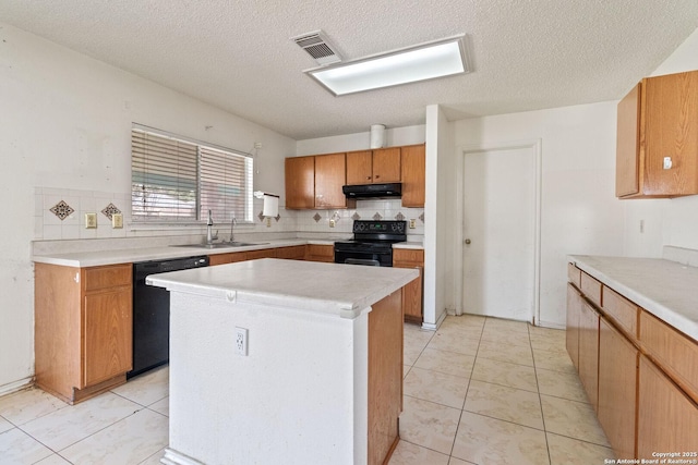 kitchen featuring black appliances, under cabinet range hood, light countertops, and a center island