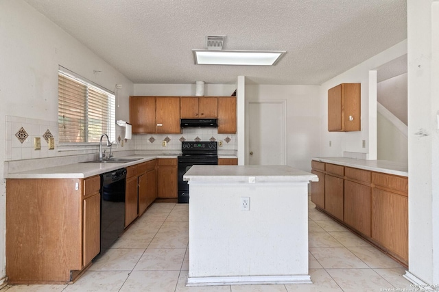 kitchen featuring a sink, black appliances, and light countertops