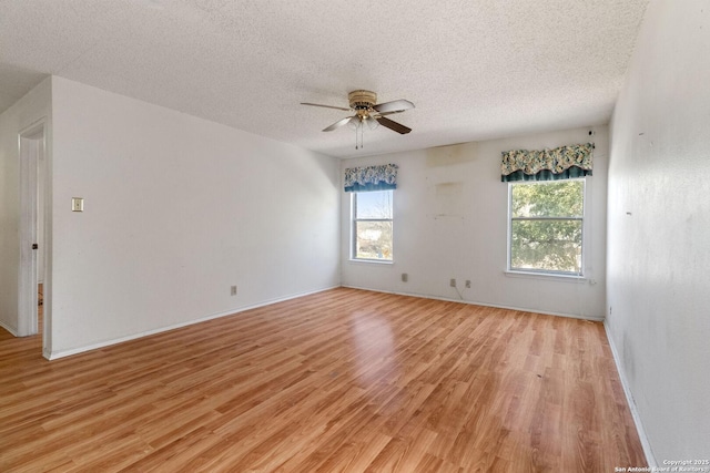 spare room with ceiling fan, a textured ceiling, baseboards, and light wood-style floors