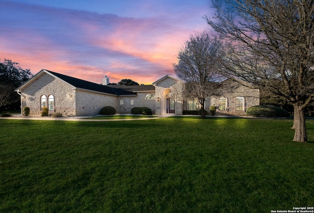 french country home featuring a chimney and a front yard