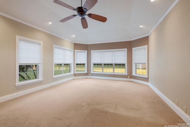 spare room featuring ornamental molding, light colored carpet, and baseboards