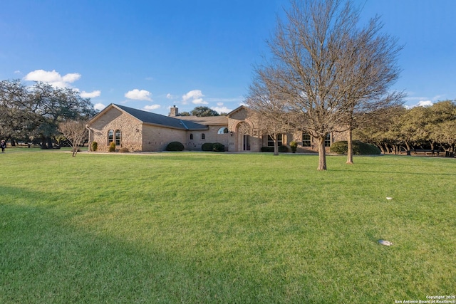 view of front of home with a front yard and a chimney