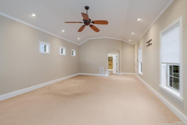 empty room featuring arched walkways, lofted ceiling, visible vents, ornamental molding, and baseboards