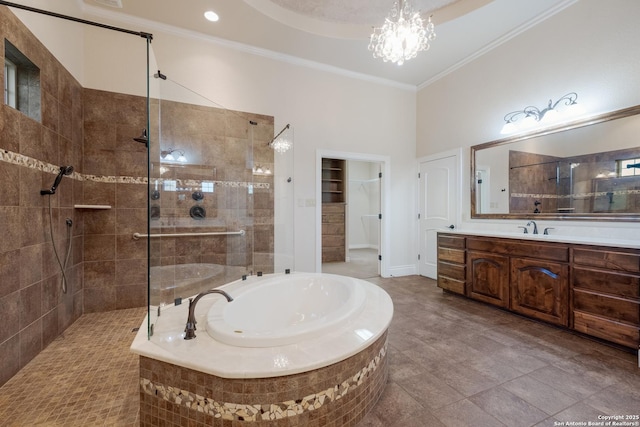 bathroom with a garden tub, a notable chandelier, vanity, ornamental molding, and walk in shower