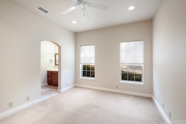 empty room with light colored carpet, a wealth of natural light, and visible vents