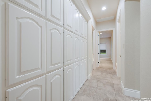 corridor with recessed lighting, baseboards, and light tile patterned flooring