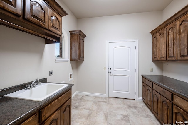 laundry room with hookup for a washing machine, a sink, baseboards, cabinet space, and electric dryer hookup