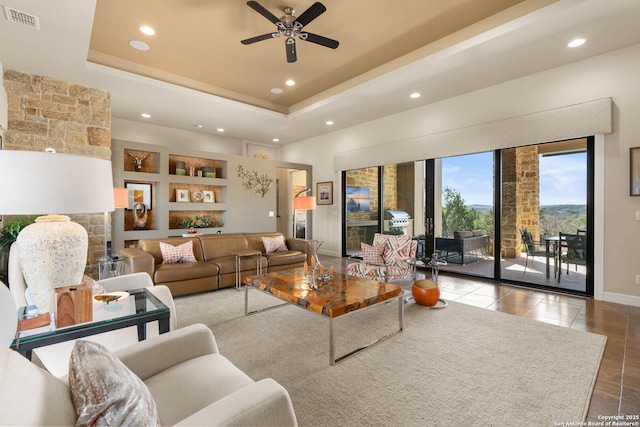 tiled living area featuring built in shelves, recessed lighting, visible vents, baseboards, and a raised ceiling