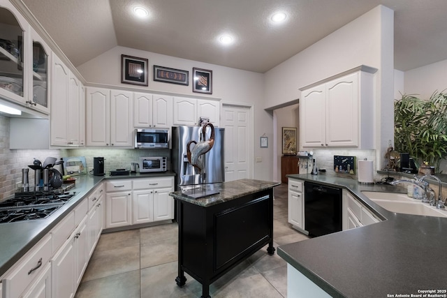 kitchen with white cabinets, glass insert cabinets, stainless steel appliances, and a sink