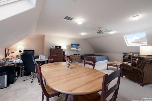 interior space featuring vaulted ceiling with skylight, visible vents, and light colored carpet