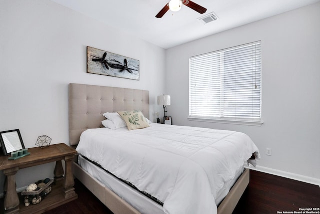 bedroom with a ceiling fan, baseboards, visible vents, and dark wood-type flooring