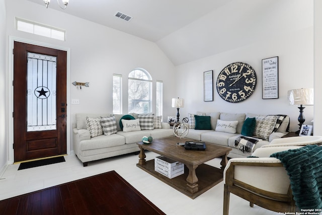 living area featuring lofted ceiling and visible vents