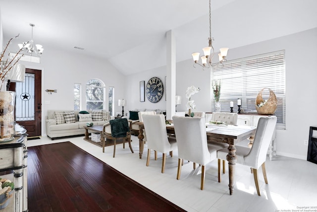 dining area featuring visible vents, vaulted ceiling, wood finished floors, a chandelier, and baseboards