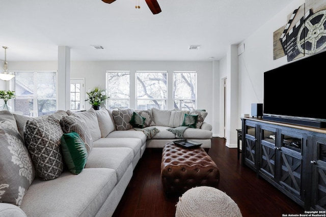 living room featuring ceiling fan, dark wood-type flooring, visible vents, and baseboards