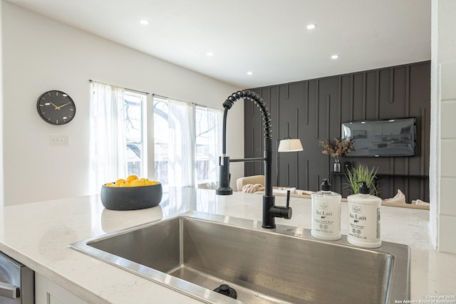 details featuring recessed lighting, a sink, and light stone countertops