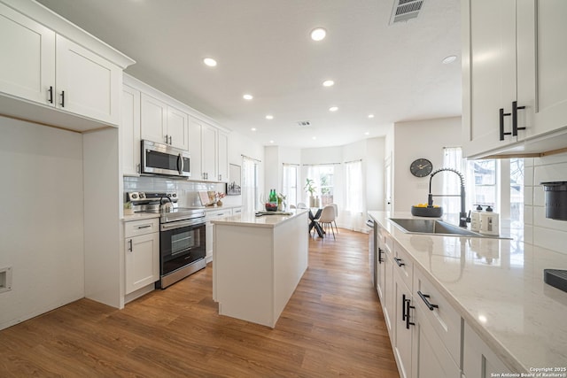 kitchen with visible vents, white cabinetry, and stainless steel appliances