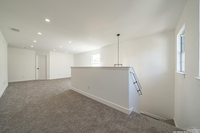 carpeted empty room with baseboards, visible vents, and recessed lighting
