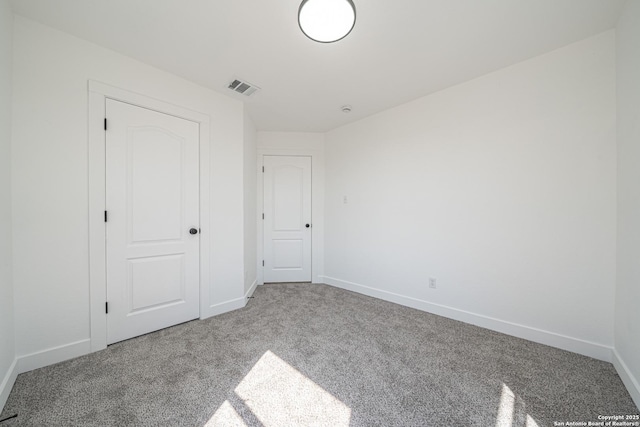 unfurnished bedroom featuring carpet, visible vents, and baseboards