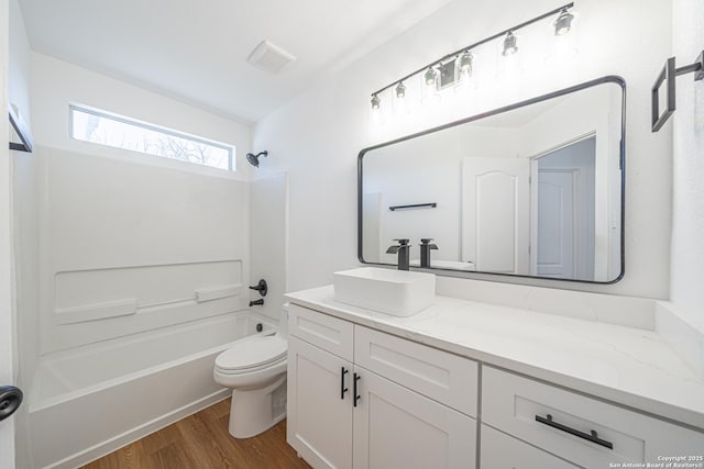 full bathroom featuring toilet, wood finished floors, bathing tub / shower combination, vanity, and visible vents