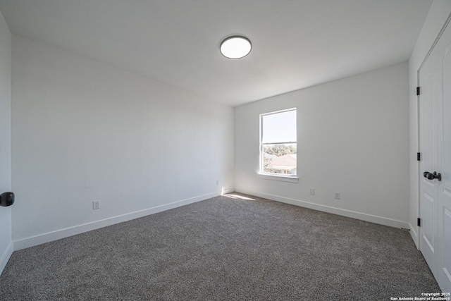 unfurnished bedroom with dark colored carpet and baseboards