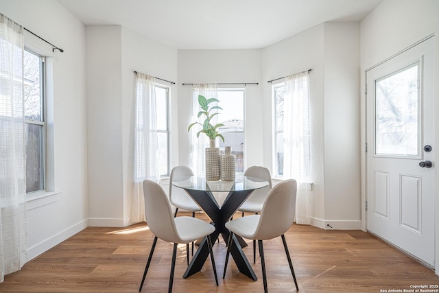 dining space with baseboards and wood finished floors