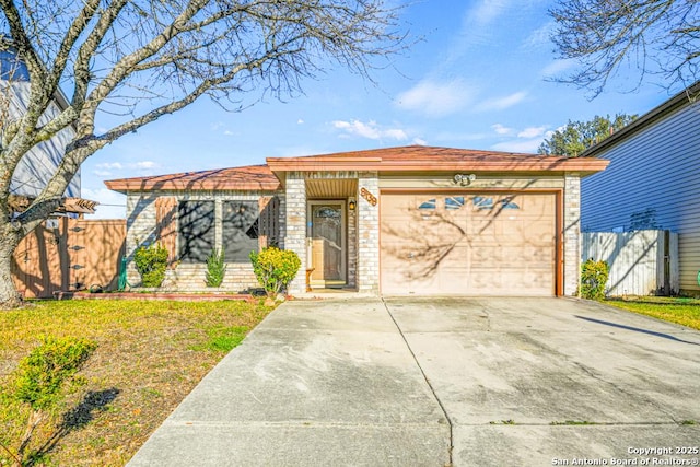 view of front of home with an attached garage, brick siding, fence, driveway, and a front lawn