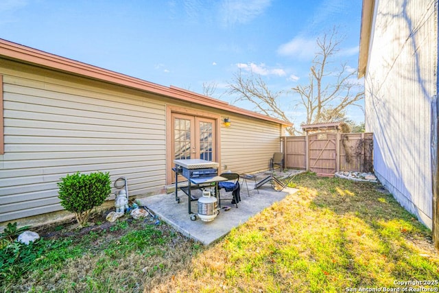 view of yard featuring a gate, a patio, french doors, and fence