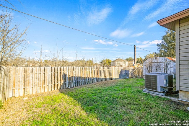 view of yard with a fenced backyard and central AC unit