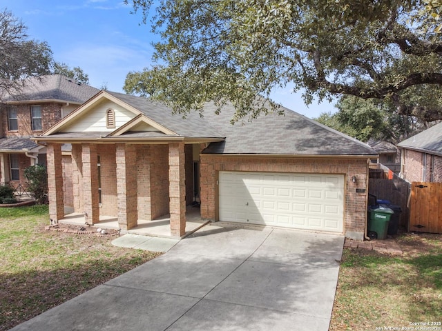 view of front of home with an attached garage, brick siding, fence, concrete driveway, and roof with shingles