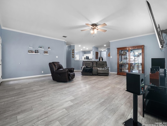 living room with crown molding, ceiling fan, light wood-type flooring, and baseboards