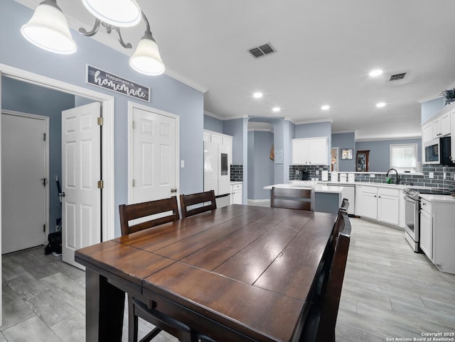 dining area with visible vents, crown molding, and recessed lighting