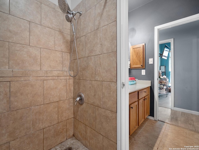 full bathroom featuring tiled shower and vanity