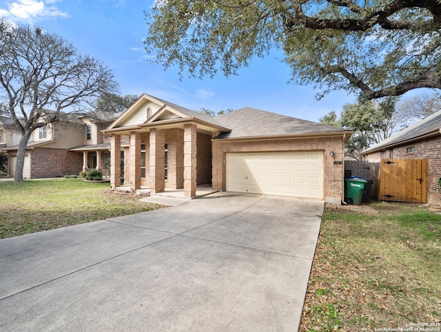 view of front of house with a garage, brick siding, fence, driveway, and a front lawn